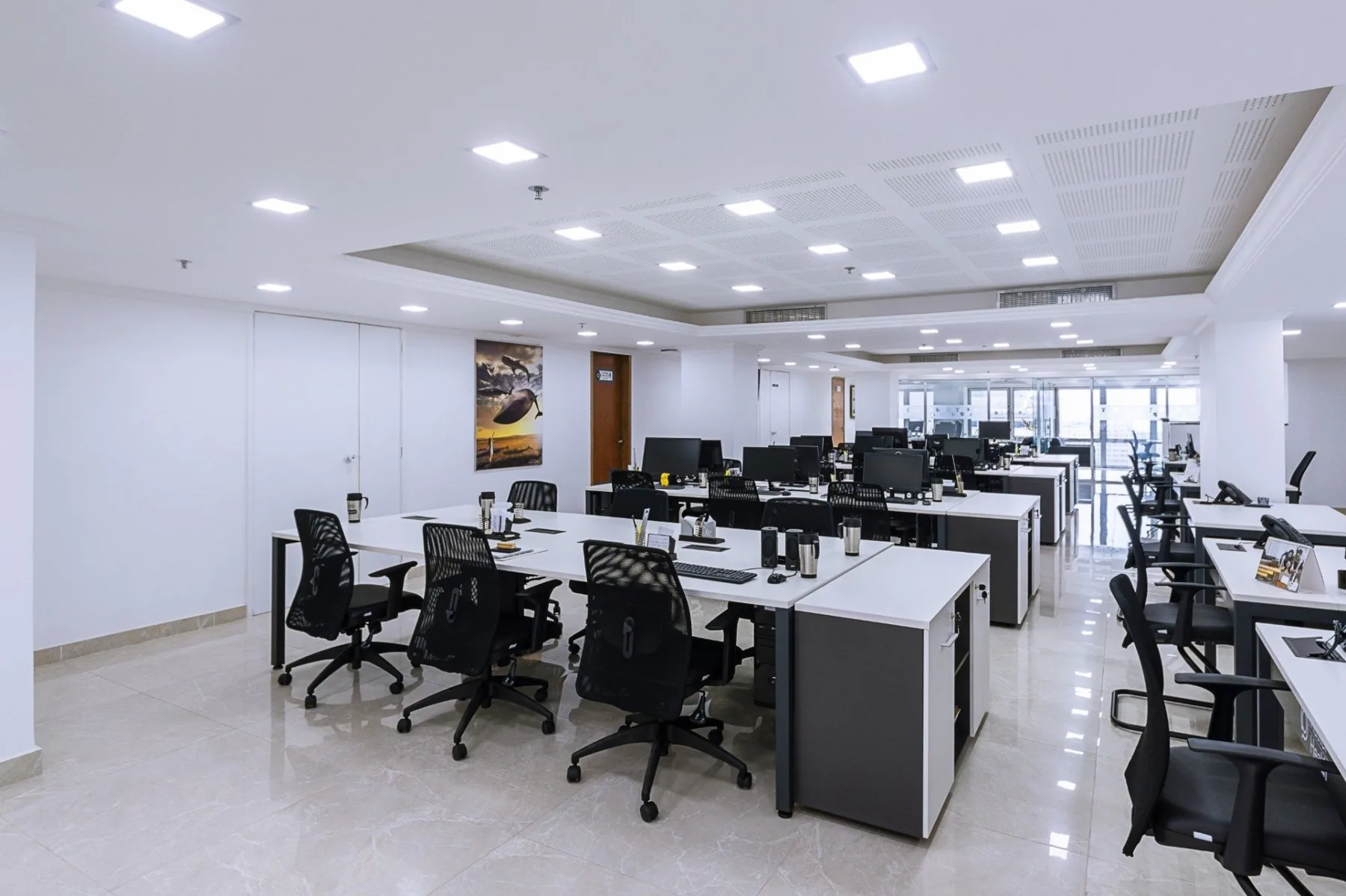 Espaço institucional em planta aberta com estações de trabalho