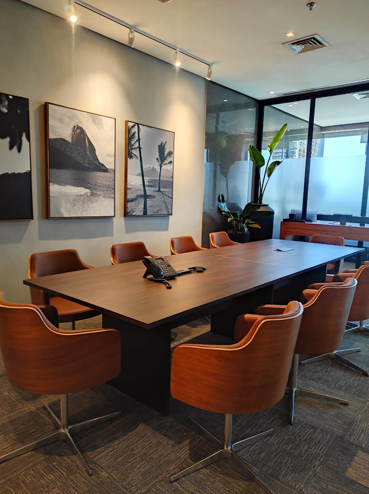 Sala de reunião corporativa com curadoria de arte e vidro